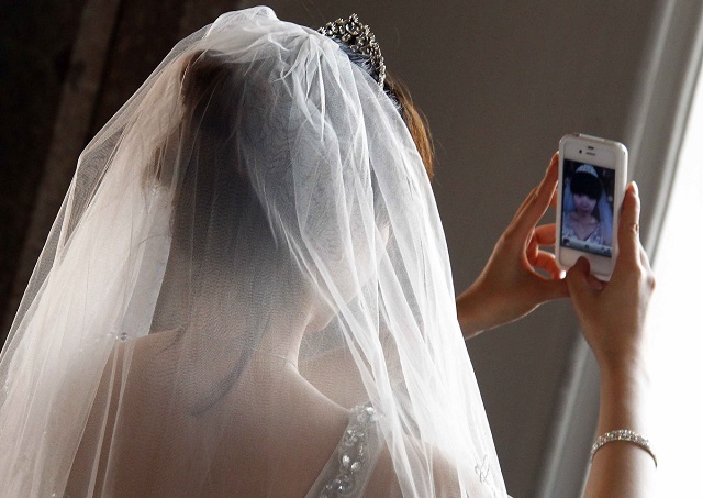 A Chinese bride takes a self portrait before her symbolic wedding in Fuessen